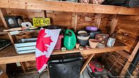 Shelf with multiple pots, planters, watering can, lantern, licence plate, trays visible