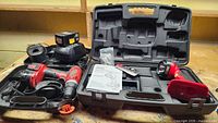 Both open cases displaying drill, worklight, batteries, charger and accessories