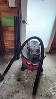 Full view of Craftsman shop vacuum with hose attached and extension wands standing upright
