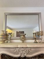 Full mantel view with mirror, shelf, vase, candle holders and lantern