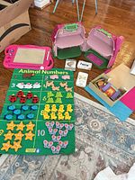 Overview of lot showing felt mat with pieces, drawing board, dollhouse halves, flash cards and FeltTales box
