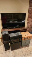 Overall lot showing TV on stand, speakers, subwoofer with Denon receiver on top, Technics box and tote