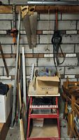 Overview of lot showing hand saws, hedge trimmers, clamp, levels, tool stand and accessory box
