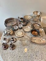 Group shot of all approximately 20 silverplate items on countertop