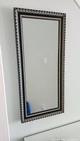 Full view of rectangular mirror hanging on wall