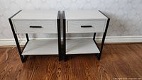Both nightstands front view showing matching design, drawers closed, shelf and metal frame