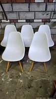 Front view of all five white plastic DSW chairs