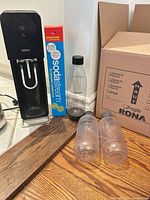SodaStream carbonator, boxed CO2 cylinder, tall bottle and two small bottles visible
