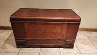 Front view of closed cedar hope chest showing veneer finish and carved molding