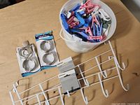 All items overview: bucket of clothespins, two shower ring packs, two hook racks