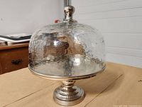 Cake stand assembled showing hammered glass dome and metal base