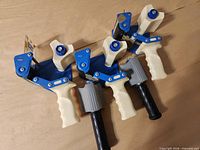 Three-quarter view of both tape dispensers showing overall design, handles and tension knobs