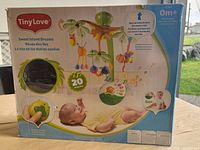Front of boxed Tiny Love Sweet Island Dreams mobile showing product image, features and age suitability