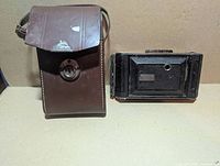 Camera folded next to leather case