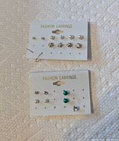 Two earring display cards with multiple stud pairs visible