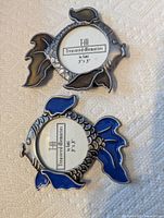 Front view of two metal goldfish frames showing enamel colors and photo openings