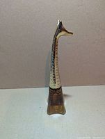 Right profile of amber glass and gold-tone giraffe perfume bottle