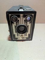 Front view showing Art Deco faceplate, lens and dual viewfinders