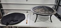 Overall view of fire pit with screen, poker and carry bag