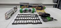 Entire lot laid out: locomotive, passenger cars on boxes, tender, transformer, controller, nine straight tracks, instruction booklet