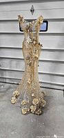 Front view of full-size wire mesh dress sculpture with gold and ivory floral accents