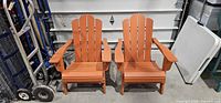 Front view of both orange folding Adirondack chairs