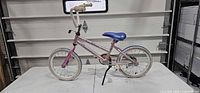 Right side view of entire pink Raleigh kids bike on table