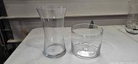 Both clear glass vases side by side showing size difference and form