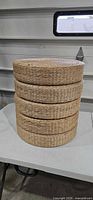 Stack of five woven cushions showing uniform size and weave