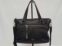 Front view showing overall style, front zip pocket, handles, strap