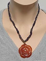 Full necklace on display bust showing iolite beads and carved carnelian pendant