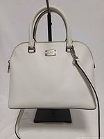 Front view of white Michael Kors Cindy dome satchel showing handles, strap and logo plate
