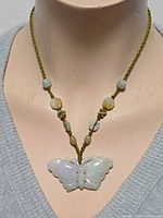 Necklace on bust showing jadeite butterfly pendant and bead accents