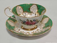 Side view of Paragon green and gold gilt teacup on saucer showing pattern details