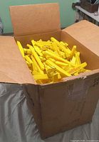 Open box filled with yellow plastic chip clips
