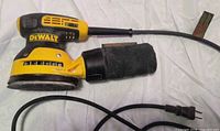 Left side view showing DeWalt branding, Velcro pad, dust bag and cord