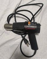 Left side view of Milwaukee heat gun showing cord and nozzle