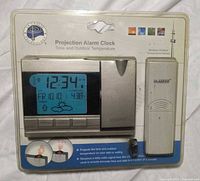 Front view of sealed La Crosse Technology projection alarm clock package showing clock, sensor and branding