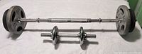 Long barbell bar and short dumbbell handle with plates attached