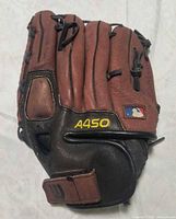 Front view of Wilson A450 glove showing MLB logo patch and wrist strap