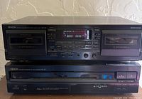 Front view of both Denon components stacked: DRW-585 cassette deck on top, DCM-340 CD changer below