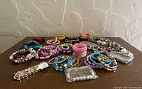 Overall view of entire bracelet lot spread on tabletop