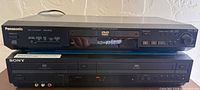 Front view of stacked Panasonic DVD-RV32 player above Sony SLV-D281P combo unit