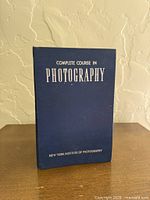 Front view of blue binder displaying title