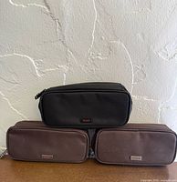 Three toiletry bags stacked; shows color and overall condition