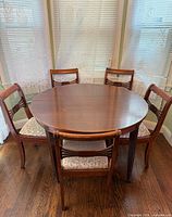 Round wood table with four matching chairs placed around it
