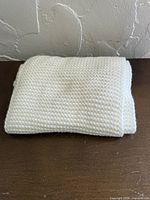 Folded white knit scarf front view