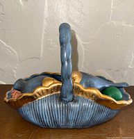 Top view of blue ceramic basket with gold rim and birds inside