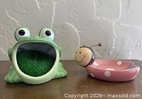Front view of green ceramic frog holder and pink ladybug dish together