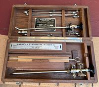 Open walnut case showing complete Brown-Buerger cystoscope set and accessories
